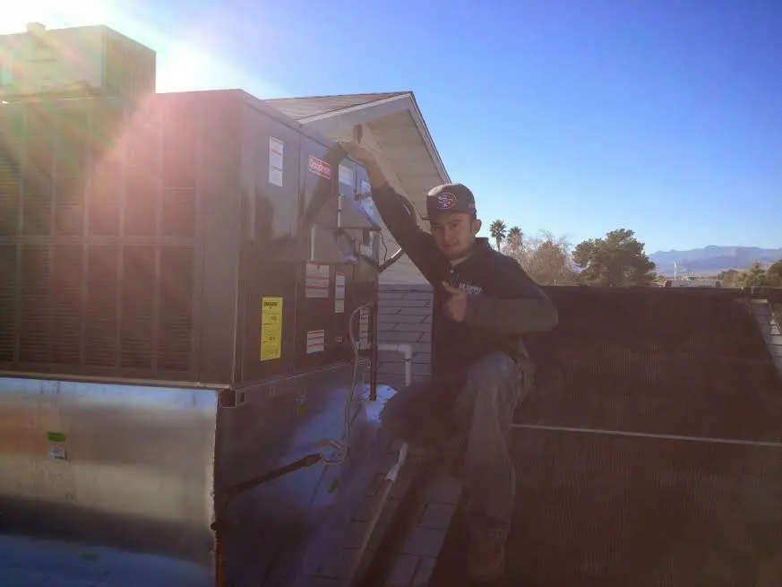 HVAC technician performing HVAC Inspection on a rooftop unit in Andover